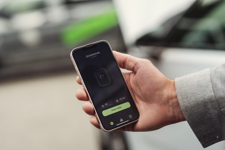 manns hånd holder sort smarttelefon med Enua-app på skjermen
