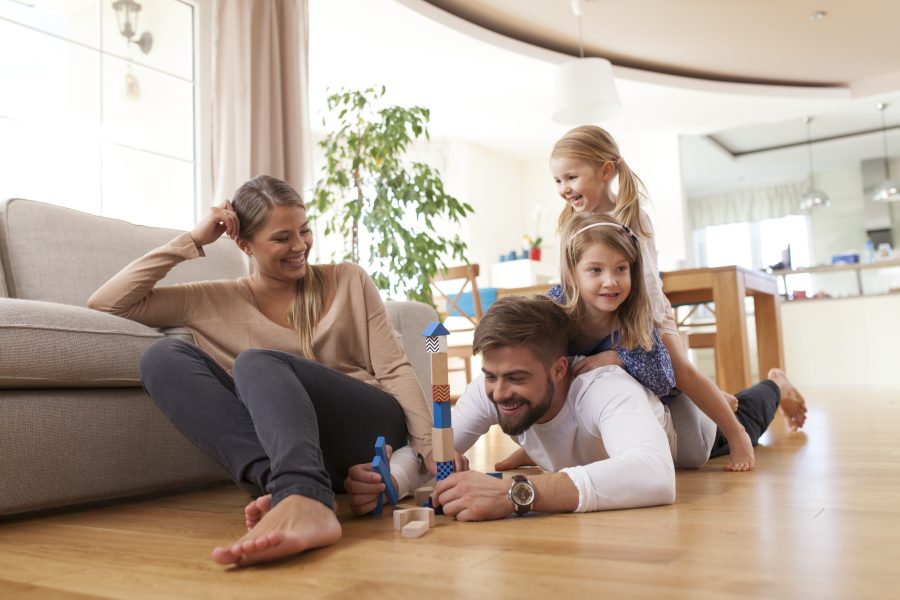 Familie leker sammen på et gulv som har gulvvarme.