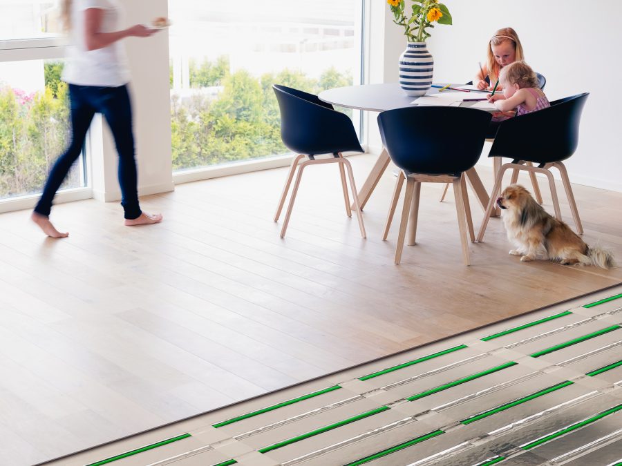 To barn, en mamma og en hund som oppholder seg i spisestue der varmekablene fra Lamiflex er plassert inn i gulvet