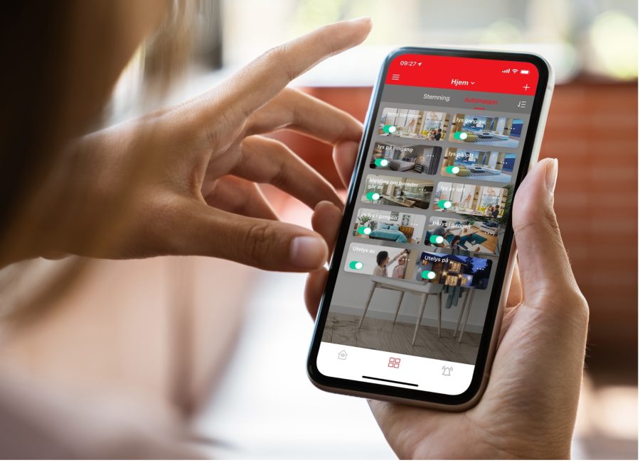 Et par hender holder en smarttelefon med ELKO Smart-appen åpen.