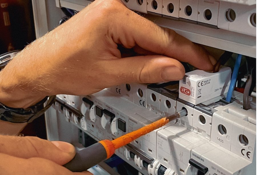Nærbilde av elektriker som installerer SmartTag fra ELKO i sikringsskap.